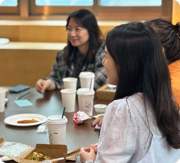 음료를 앞에 두고 마주 앉아 이야기하는 두 사람